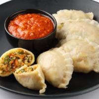 The Chili Vegetarian Momo · Exquisite chef's chili sauce tossed over cooked vegetarian dumplings for extravagant taste.