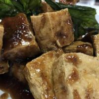 Tofu Grob · Fried tofu tossed in a sweet onion and garlic glaze. Topped with crispy basil.