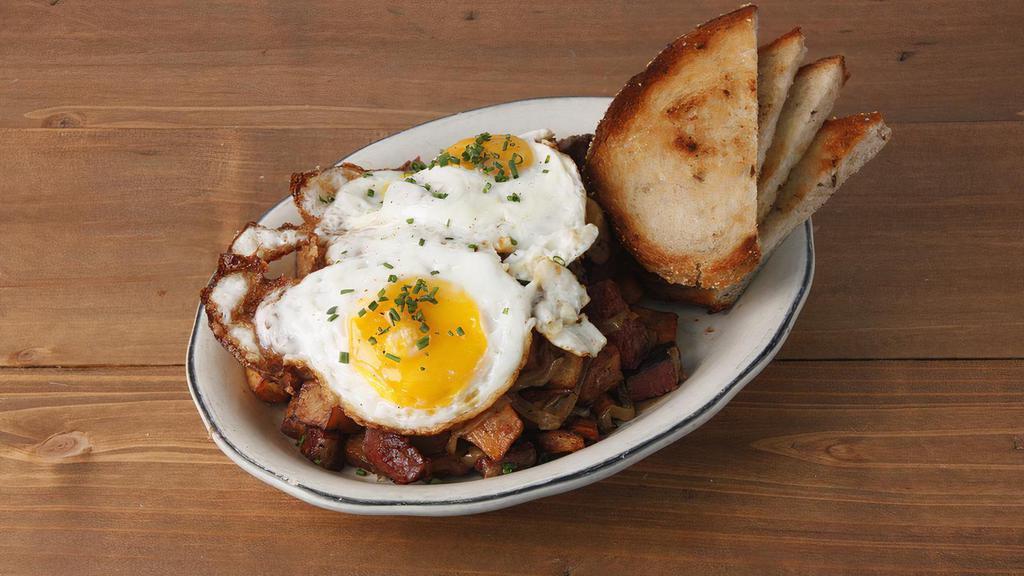 Corned Beef Hash * · pieces of corned beef, caramelized onions, roasted peppers, & crispy potatoes topped with sunny side up eggs and your choice of toast.