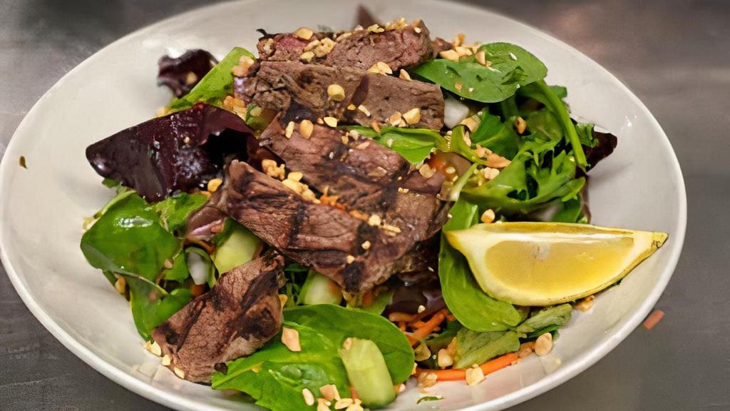 Thai Steak Salad · New York Strip Steak, Mixed Greens, Tomatoes, Cucumbers, Carrots, Red Onions, Peanuts, Mixed Herbs with Lime Vinaigrette Dressing