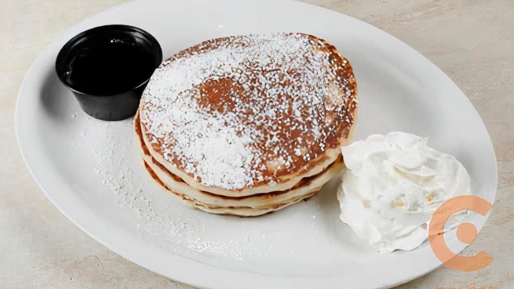 Buttermilk Pancakes · Three Buttermilk Pancakes with Powdered Sugar.  Served with 100% Maple Syrup
ADD ONE OF THE FOLLOWING TOPPINGS 
– Blueberry Compote
– Banana, Roasted Walnuts & Nutella
– Banana, Strawberries & Nutella
– Cinnamon Apple Compote & Roasted Walnuts