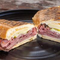 The reuben sandwich · Pastrami, swiss cheese, sauerkraut, pickles, specialty reuben dressing on a toasted po’boy r...