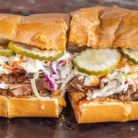 BBQ pulled pork sandwich · Slow smoked pulled pork, coleslaw, pickles, mild mustard BBQ saucer on a toasted po’boy roll
