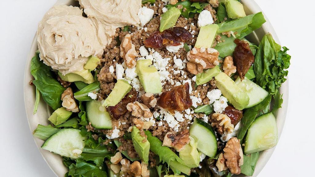 The Yummus Bowl · Spring Mix and Quinoa base, topped with Dates, Cucumber, Hummus (mixed with beet juice for October), Avocado, Feta Cheese, Walnuts, and your choice of dressing.