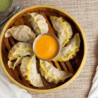 Chicken Momo · Nepali delicacy cooked with ground chicken and Himalayan spices filled in cover with thin fl...