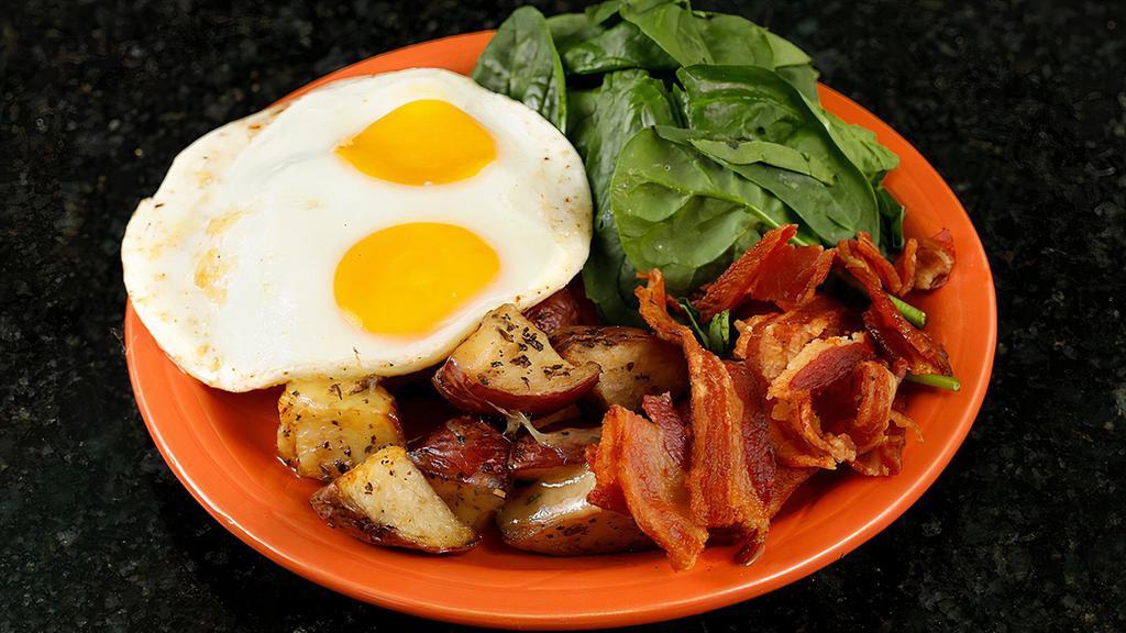Eggs D'acajou · 2 eggs on a bed of spinach, topped with melted gruyere cheese, bacon and a side of roasted potatoes.