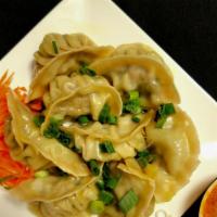 Chicken Momo (8 pcs) · Steamed dumplings filled with minced cabbage, broccoli, onion, and special spices. Vegan.