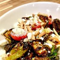 Coles de Bruselas · Roasted Brussels, tossed in Thai Chili, Toasted Almond, and balsamic Reduction