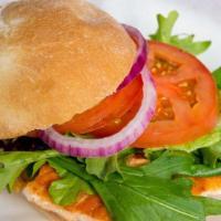 Salmon Burger · With mixed greens, tomatoes, onions and tartar sauce.