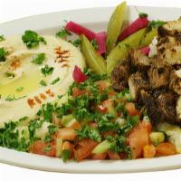 Chicken Shawarma Plate · The chicken shawerma plate includes chicken shawarma on top of white rice with a side of hum...
