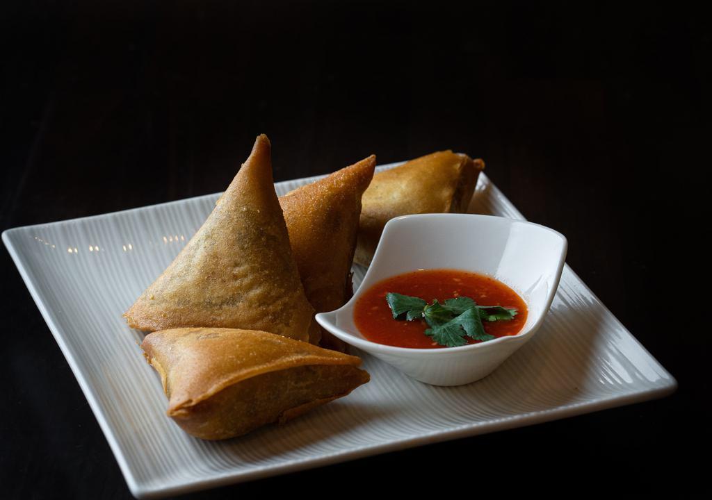 Samosas · Hand-made wheat-flour wraps fried and filled with potatoes, onions, and secret spices. Served with our special house sauce.