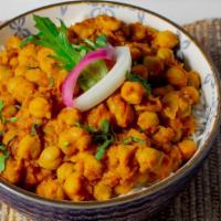 Chana Masala · Variety of chickpeas, onions and tomato on a layer of rice.