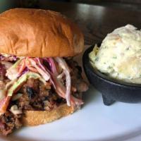 Pulled Pork Sandwich · smoked pulled pork pickles, tangy coleslaw, house bbq sauce on sesame bun + one side