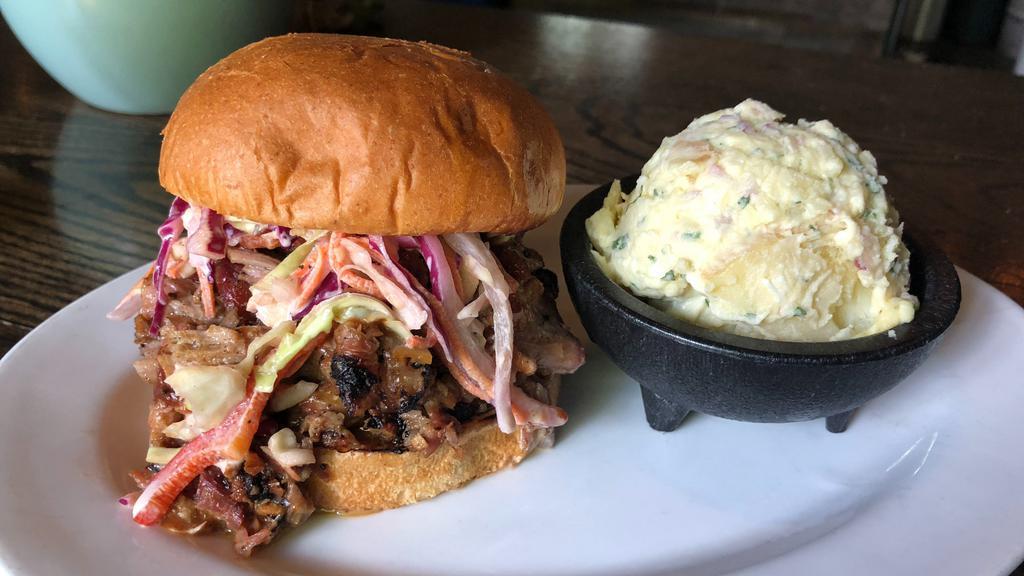 Pulled Pork Sandwich · smoked pulled pork pickles, tangy coleslaw, house bbq sauce on sesame bun + one side
