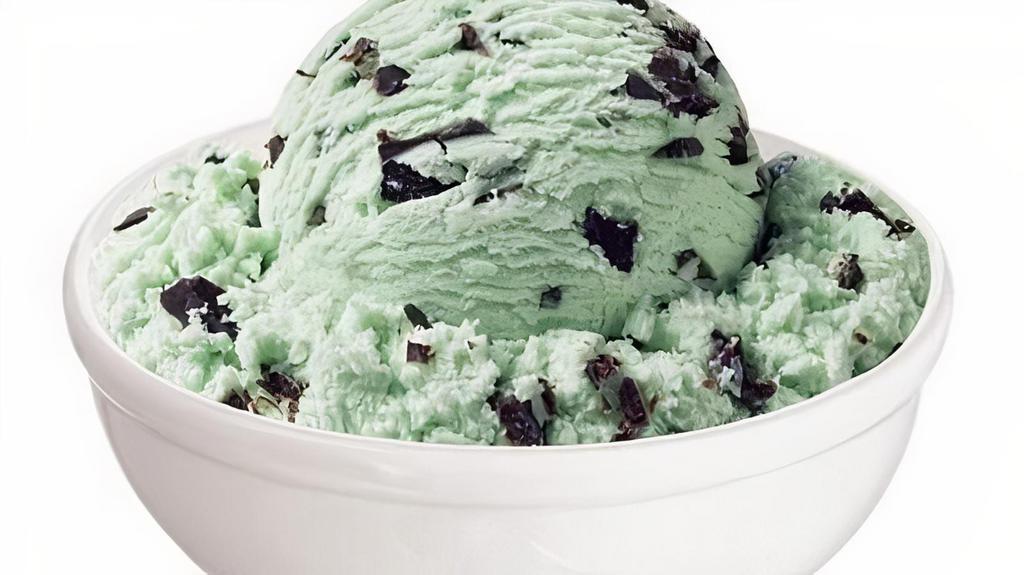 Minted Ice Cream · A large scoop of mint ice cream, sandwiched between two old-fashioned oatmeal cookies, and dipped in dark chocolate