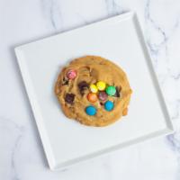 M&M OG Cookies · Made from chocolate chunk cookie dough topped with Hershey's Kisses, semi sweet chunks and M...