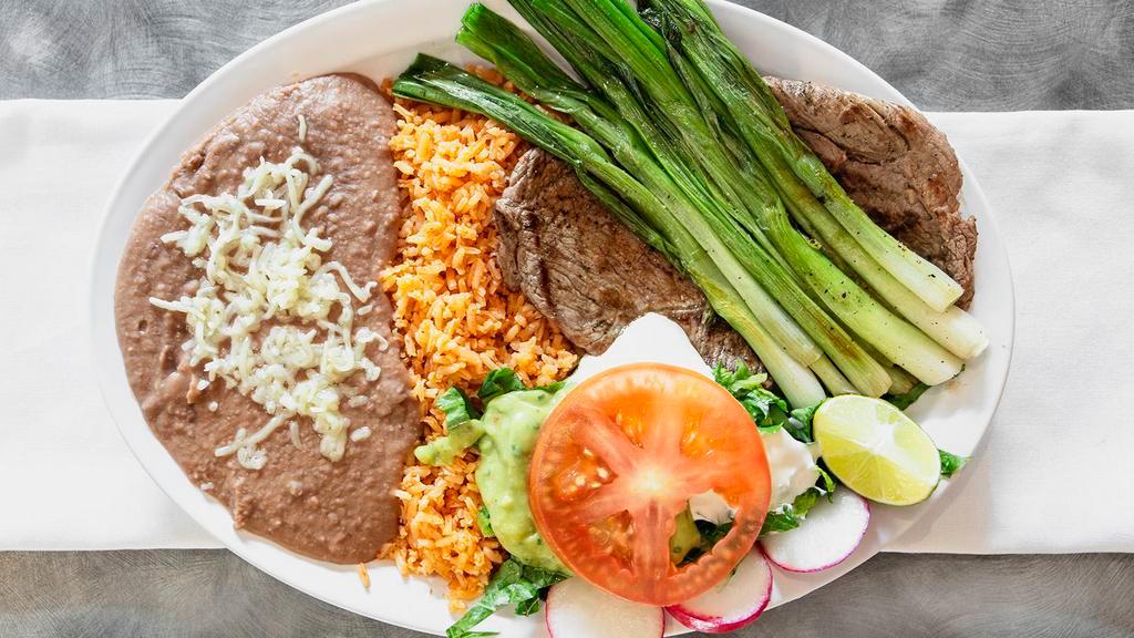 Steak Plate · Grilled steak with green onions, rice, beans, sour cream, guacamole, salad and corn tortillas.