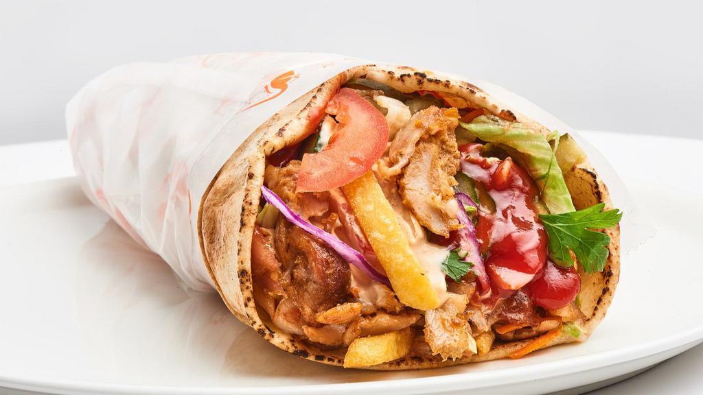 Spicy Chicken Shawarma Wrap · Fresh halal chicken shawarma with spices, hummus, lettuce, tomatoes, red onions, pickles, cucumbers, yogurt sauce and tahini sauce on warm lavash bread.