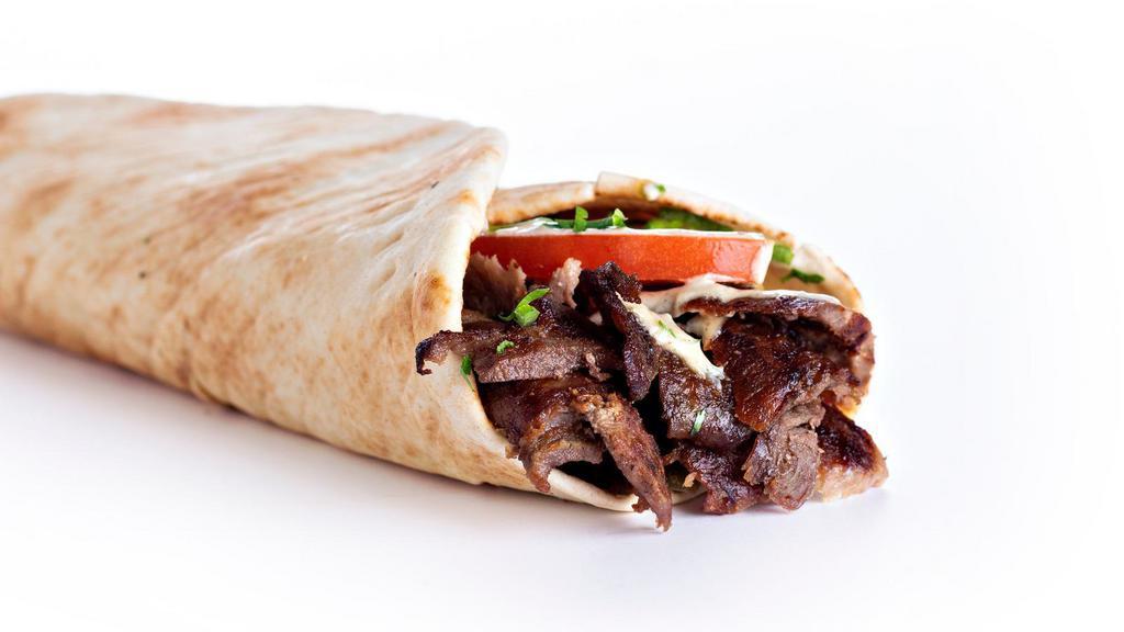 Beef Shawarma Wrap · Fresh sliced marinated beef shawarma with hummus, lettuce, diced tomatoes, red onions, pickles topped with chef's special cucumber yogurt sauce.