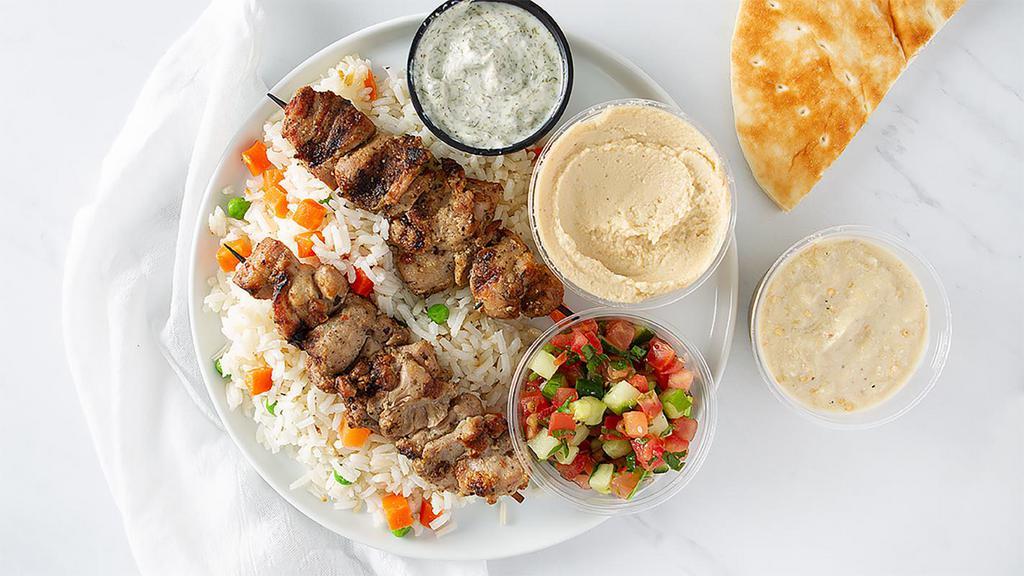 Chicken Kabob Platter · Halal, gluten-free. Slowly grilled tender and juicy chicken skewers (2) marinated in our house-blend of herbs and spices served with rice pilaf, garlic hummus, tomato-cucumber salsa, yogurt sauce, baba ganouj, and pita bread.
