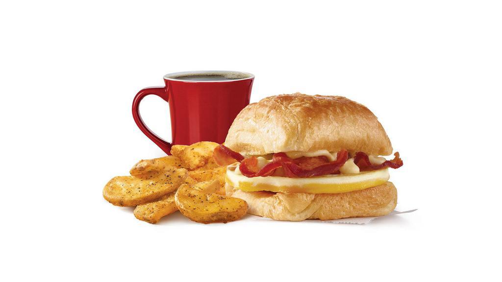 Bacon, Egg & Swiss Croissant Combo · A fresh-cracked grade A egg and Applewood smoked bacon covered in creamy swiss cheese sauce on a flaky croissant bun. Breakfast basics worth waking up early for.