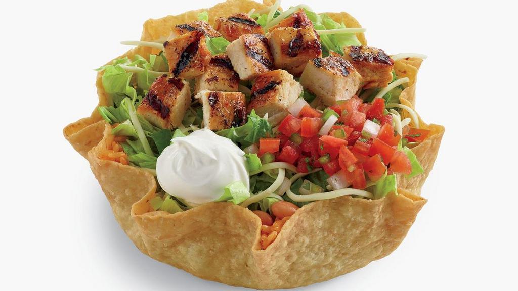 Classic Chicken Tostada Salad · A delicious combination of citrus-marinated chopped chicken, chopped romaine lettuce blend, pinto beans, rice, shredded jack cheese, sour cream and pico de gallo salsa in a crisp flour tostada shell. Served with creamy cilantro dressing. Includes chips and salsa.