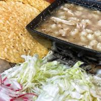 Large Chicken Pozole · Chicken soup with hominy and shredded chicken, on the side green cabbage, radishes, and onio...