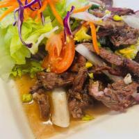 Spicy Steak Salad · Sliced marinated grilled steak, red onions, cilantro, tomatoes, cucumbers, lettuce, carrots,...