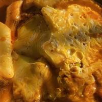Tteokbokki · Rice cakes and fish cakes, carrots, onions, green onions in a spicy red sauce topped with sh...