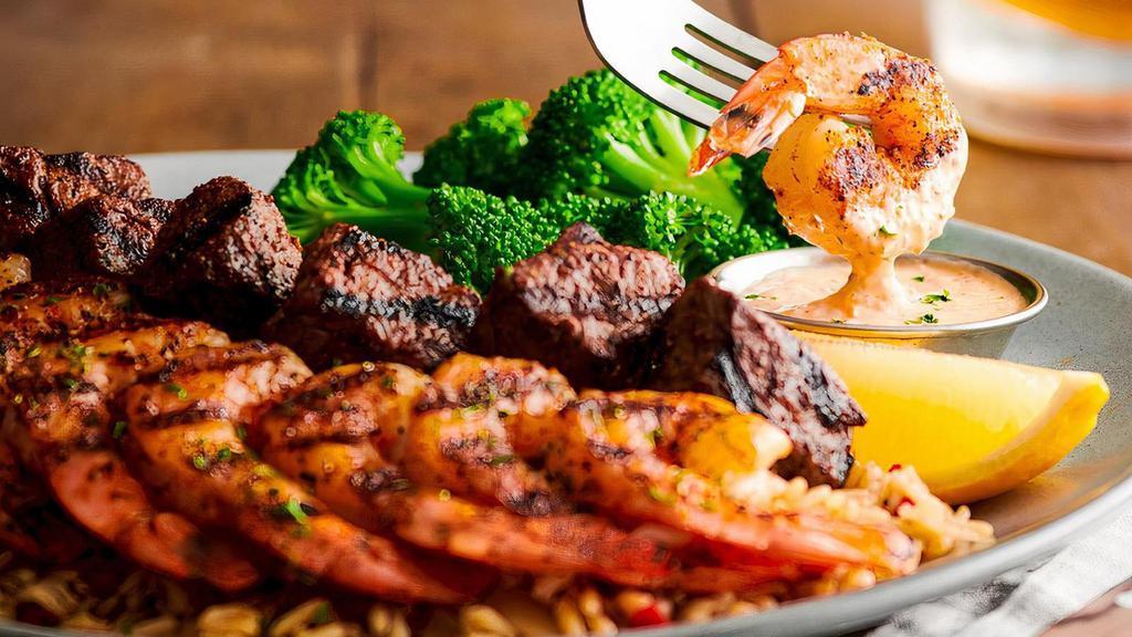Filet* & Shrimp On The Barbie · Chargrilled filet medallions and Grilled Shrimp on the Barbie over boldly seasoned rice. Served with a side of rémoulade and fresh seasonal veggie.