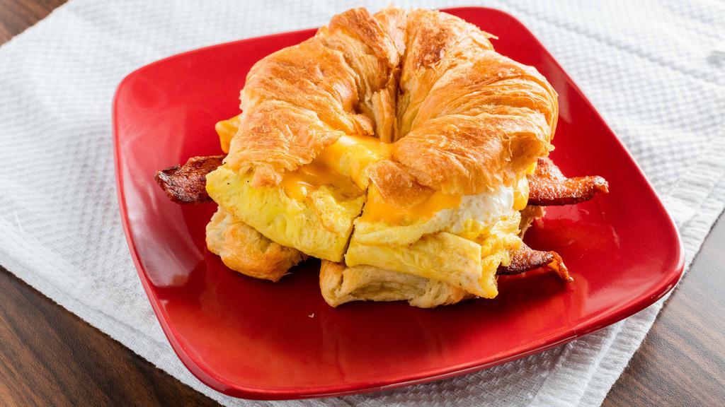 Breakfast Croissant · Three scramble eggs, American cheese, mayo and meat of your choice between bacon, sausage links and ham.