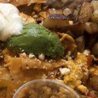 Chilaquiles · Crispy corn tortilla chips cooked with two srambled eggs, seasoned ground beef, caliente ran...