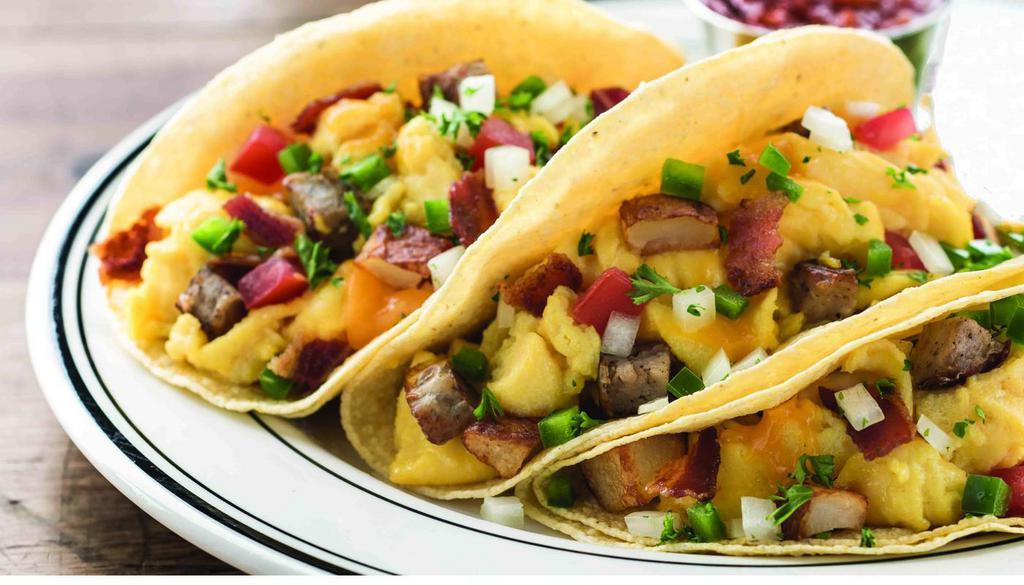 Farmhouse Tacos · Hickory-smoked bacon, sausage, scrambled eggs, roasted potatoes, cheddar cheese, jalapeno, tomato, onion and cilantro in flour tortillas. Served with salsa. (1140 cal)