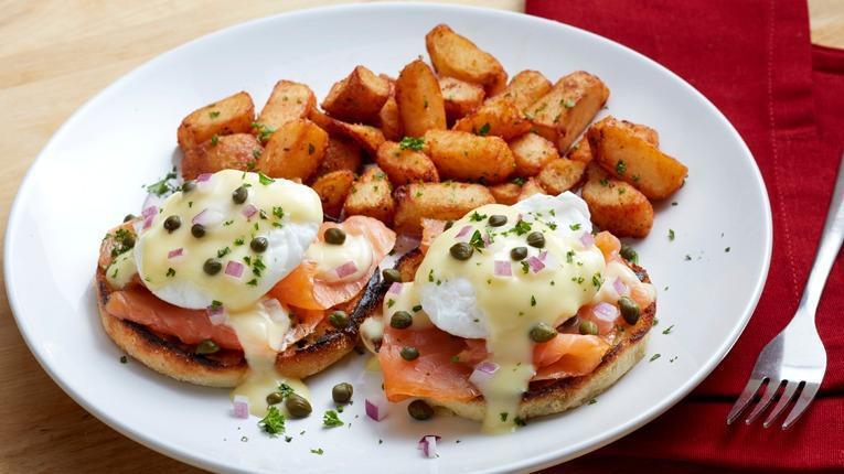 Smoked Salmon Benedict · Cold-smoked Atlantic salmon and poached eggs, topped with hollandaise sauce, diced red onions and capers on a grilled English muffin. Served with a side of roasted potatoes. (600 cal) Available every day until 2:00PM