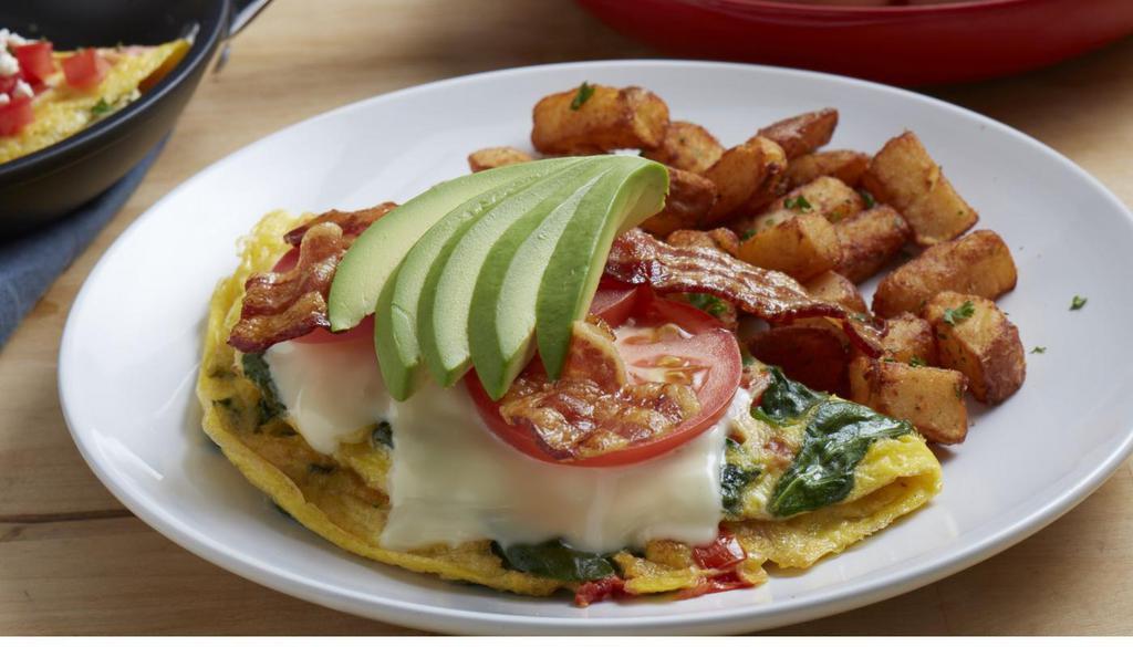 Bacon Avocado Omelet · Three eggs, hickory-smoked bacon, spinach, tomatoes, Monterey jack cheese and avocado. Served with roasted potatoes. (920 cal) .