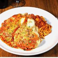 Chicken Parm · Crispy hand breaded parmesan chicken breast with melted mozzarella and marinara sauce over l...