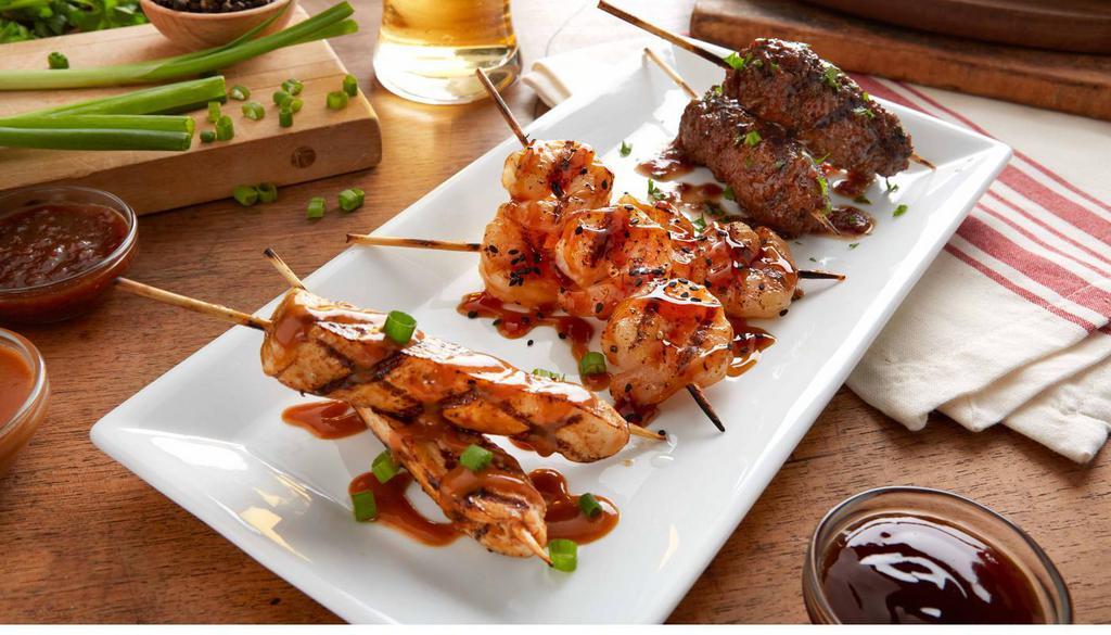 Brochette Trio · Skewers of grilled spicy peanut chicken, teriyaki shrimp and ground beef with red wine sauce. (660 Cal)