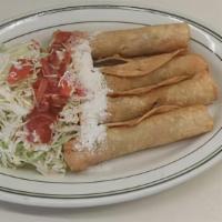 Nicaraguense Taquitos · Fried rolled taquitos with chicken topped with cabbage salad, some cream sprinkled with grat...