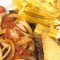 Steak & Onion/ Bistec Encebollado · Served with fried rice mixed with beans, handmade plantain chips, fried cheese and salad.