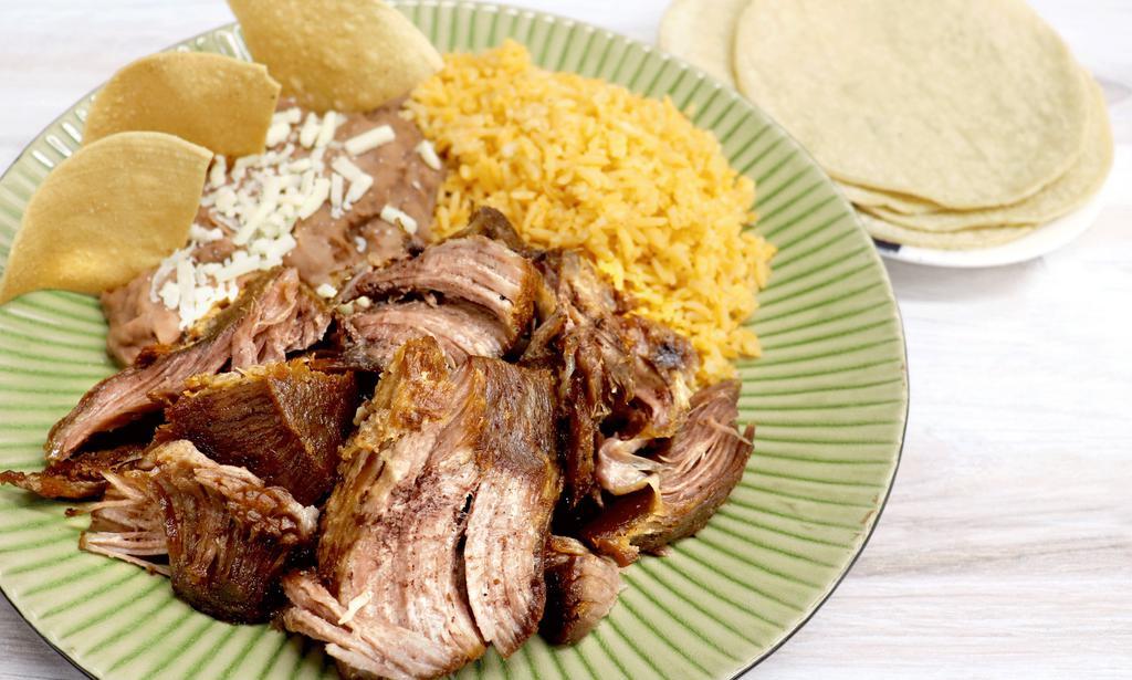 Carnitas Plate · Plato de carnitas. Served with rice, refried beans, tortillas, choice of green or red salsa, and lime.