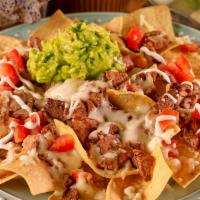 Nachos Al Gusto · Tortilla chips topped with refried beans, cheese, tomatoes, guacamole, sour cream, and choic...