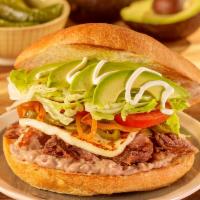 Torta Al Gusto · Stuffed with refried beans, mayonnaise, sour cream, avocado, lettuce, tomatoes, caramelized ...