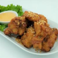 Thai Chicken Wings · Battered chicken wings deep fried, topped with fried garlic, served with sweet and sour sauce.