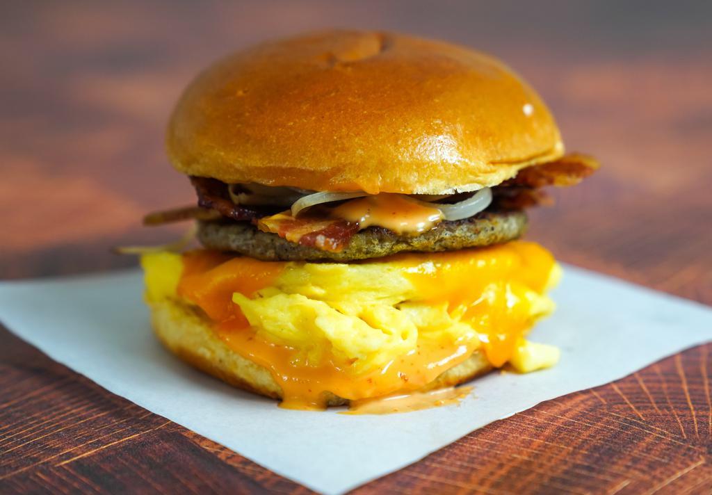 Brioche, Bacon, Sausage, Egg, And Cheese · 2 fresh cracked cage-free scrambled eggs, melted Anerican cheese, bacon, breakfast sausage, and Sriracha aioli in a warm brioche bun