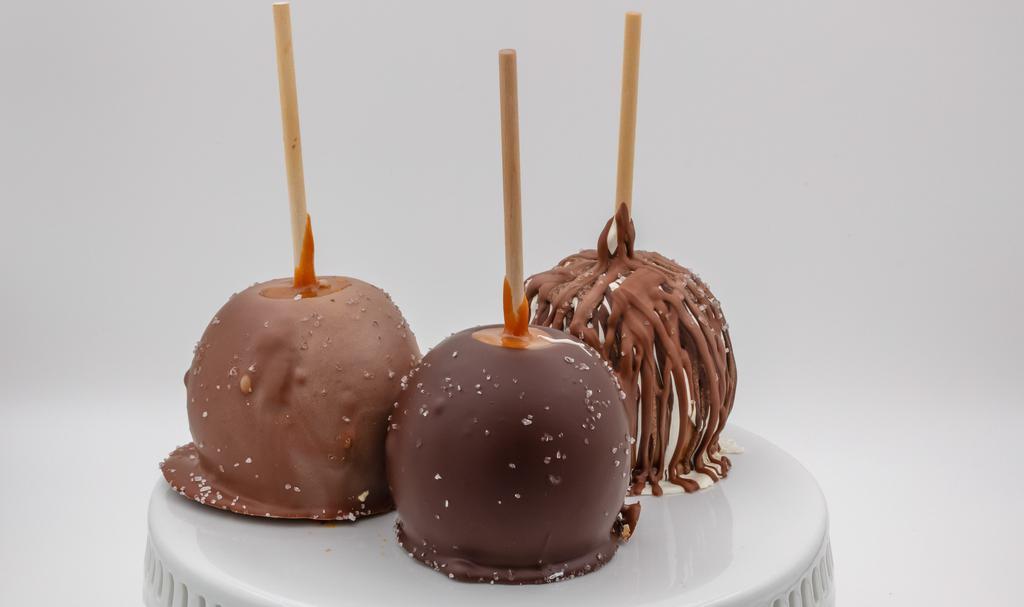 Chocolate Sea Salt Caramel Apple · Caramel apple topped with white, dark, and milk chocolate drizzle, then sprinkled with sea salt.