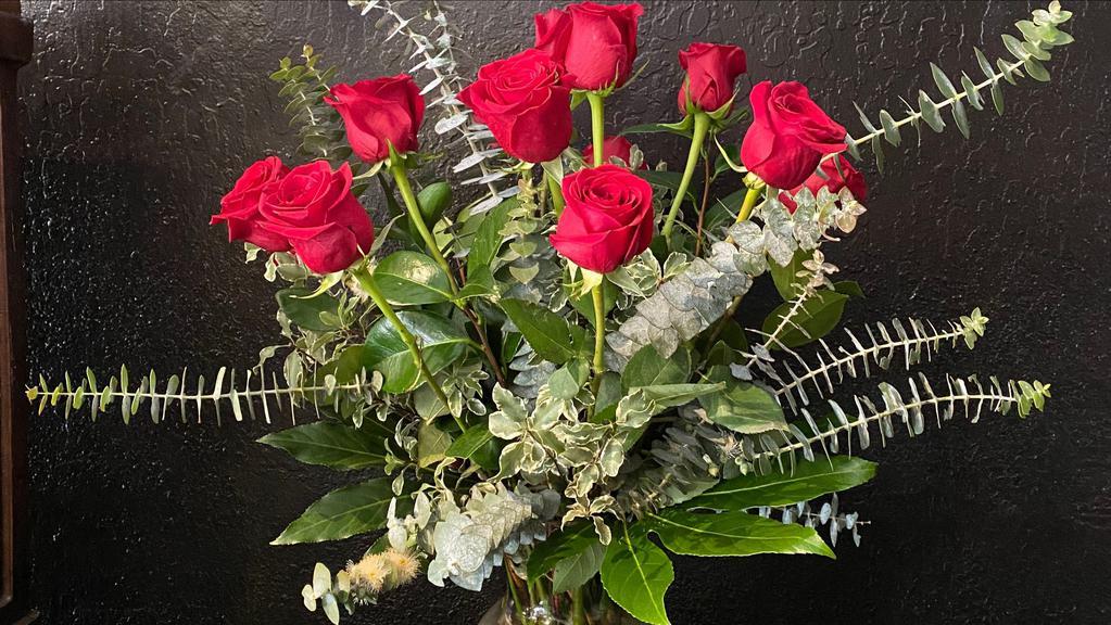 Dozen Roses  · Ye olde dozen red roses in the classic styling with full greenery in a glass vase. Color options are available so call in advance to confirm.
