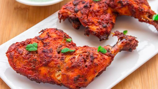 Tandoori Chicken · Juicy spring bone-in chicken marinated with yogurt with flavorful, fresh ground spices. Served with sliced onions and lemons.