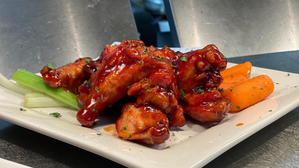 The District Traditional Wings · Bone-in chicken wings tossed in our own District wing sauces served with celery and carrots. Choice of bleu cheese dressing or ranch dressing. Available flavors: Original Buffalo, Lemon Pepper, BBQ, Cajun, Asian, Garlic Parmesan, Simply Fried 
Pictured: BBQ Wings
