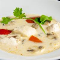 Tom Kha · Creamy coconut broth with white and green onions, mushrooms and tomato topped with cilantro.