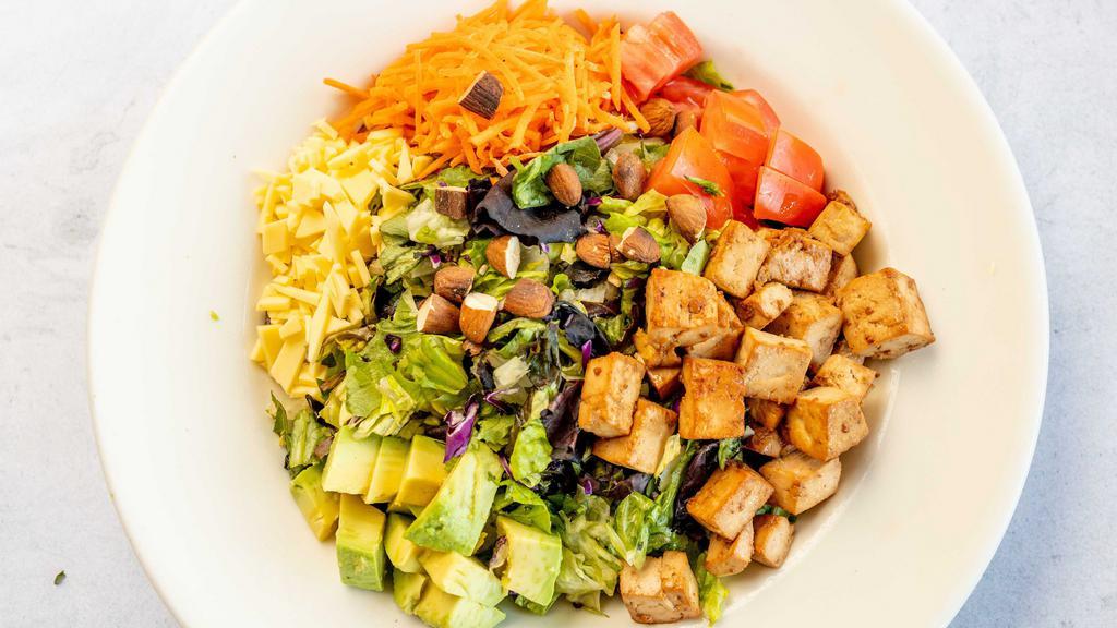 Vegan Cobb Salad · Sauteed tofu, avocado, vegan cheese, chopped almonds, shredded carrots and tomatoes, served on a bed of organic mixed baby greens and romaine lettuce tossed in our tahini dill dressing. Vegan.